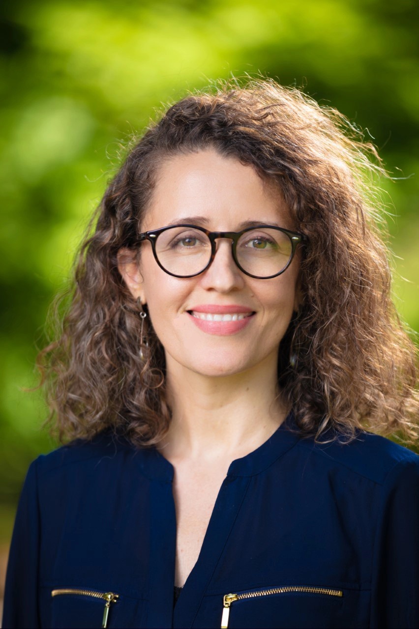 Headshot of a women wearing a blue shirt and eye glasses