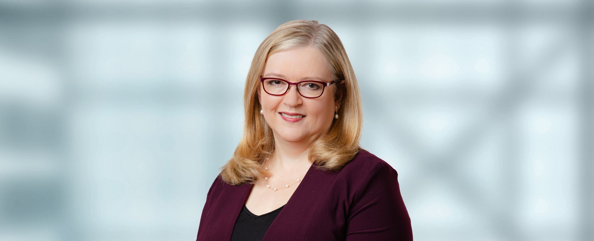 A woman wearing glasses in a purple shirt