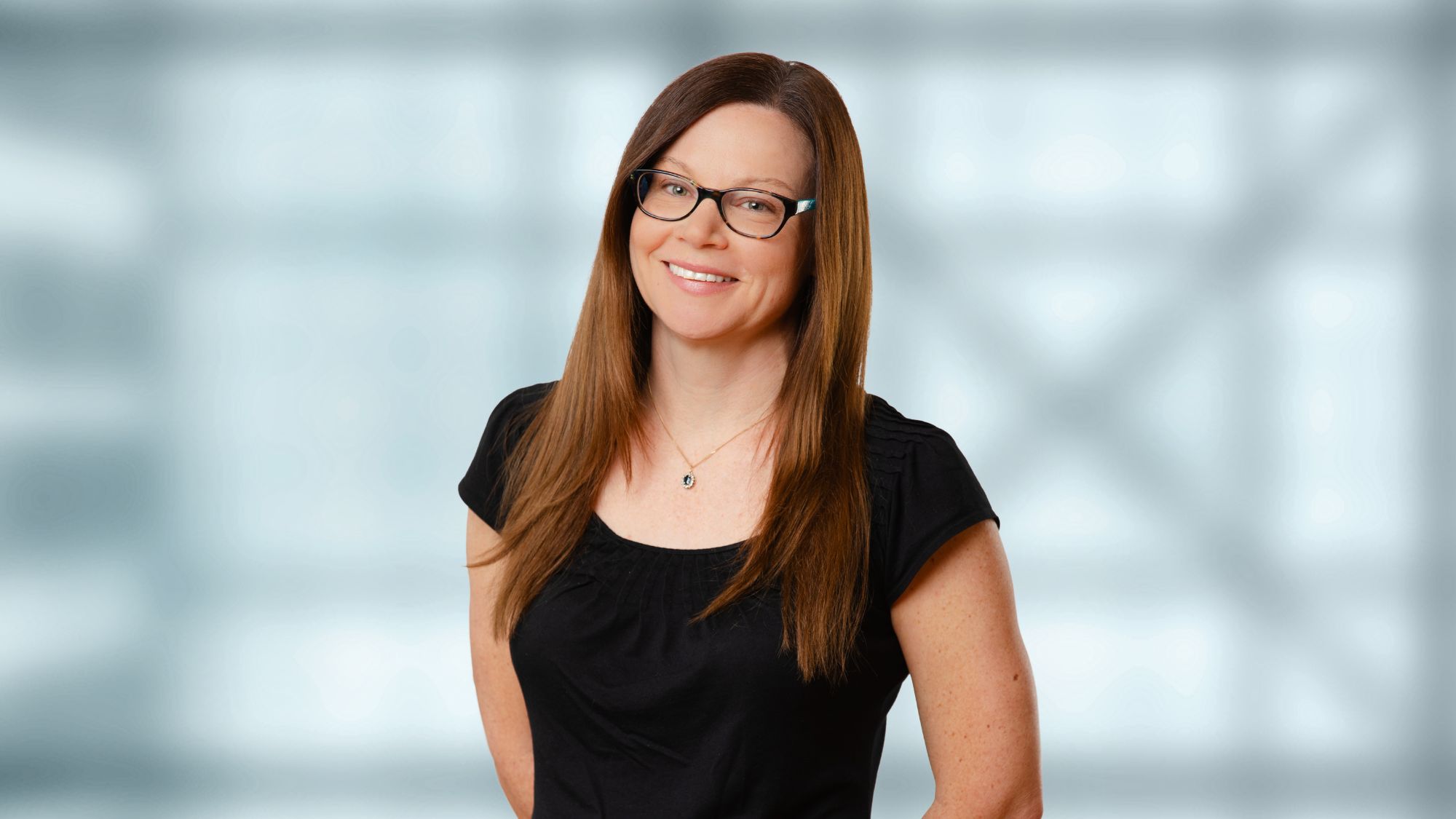 A headshot of a woman wearing a dark shirt. 